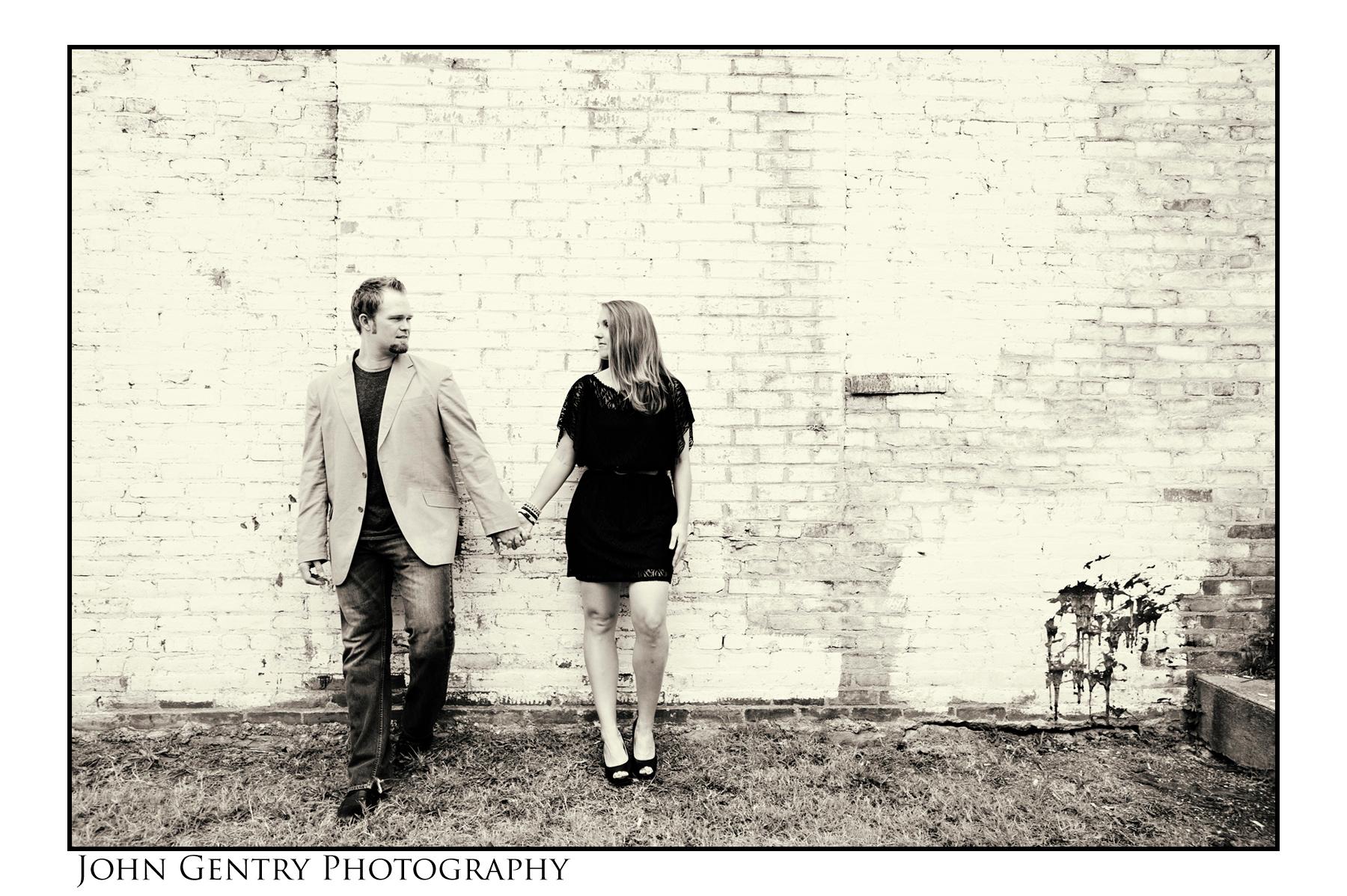 Couple holding hands against white wall