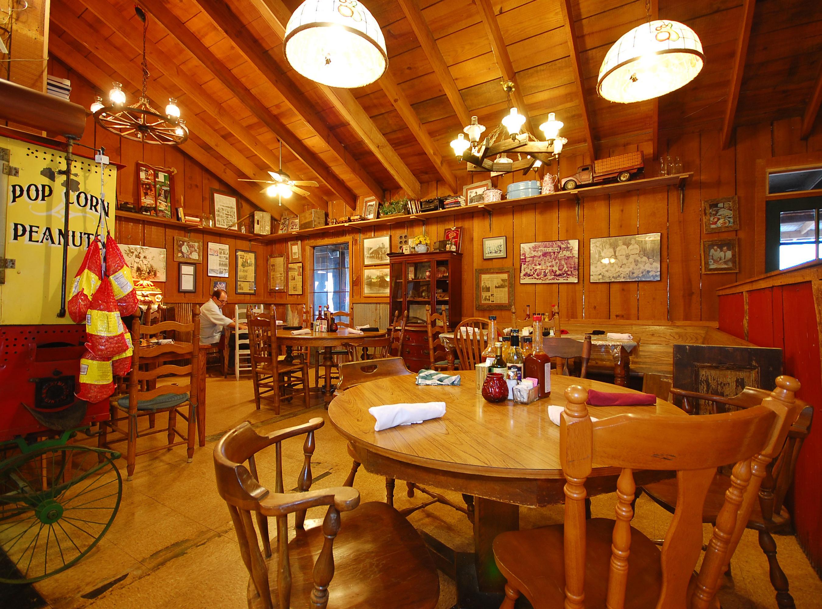 The Main dining room of The Smoke House is rustic chic with antiques, collectables and old wood walls and heavy timbered ceiling.