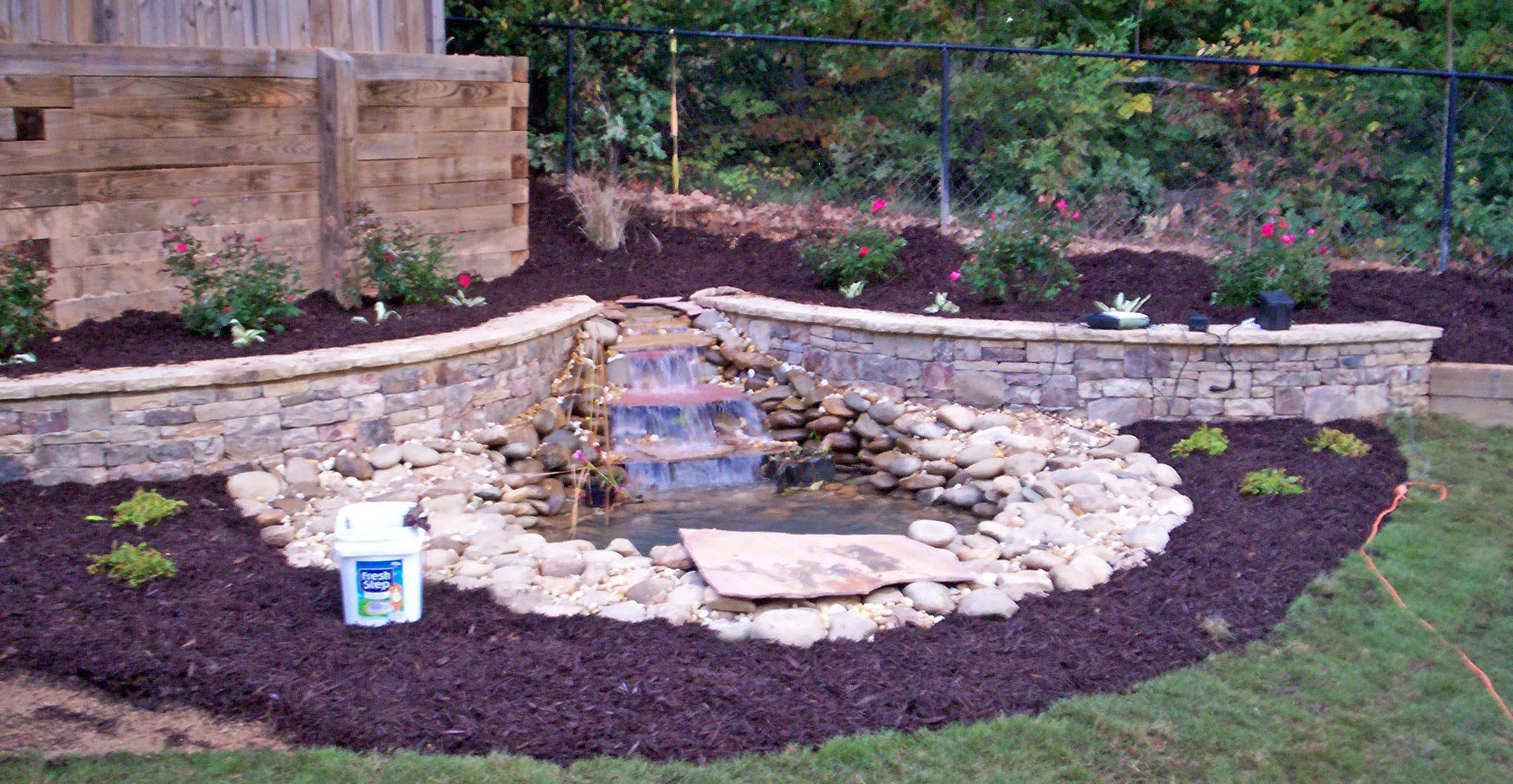 pond with matching retaining walls, small waterfall, new sod, mulch & plants