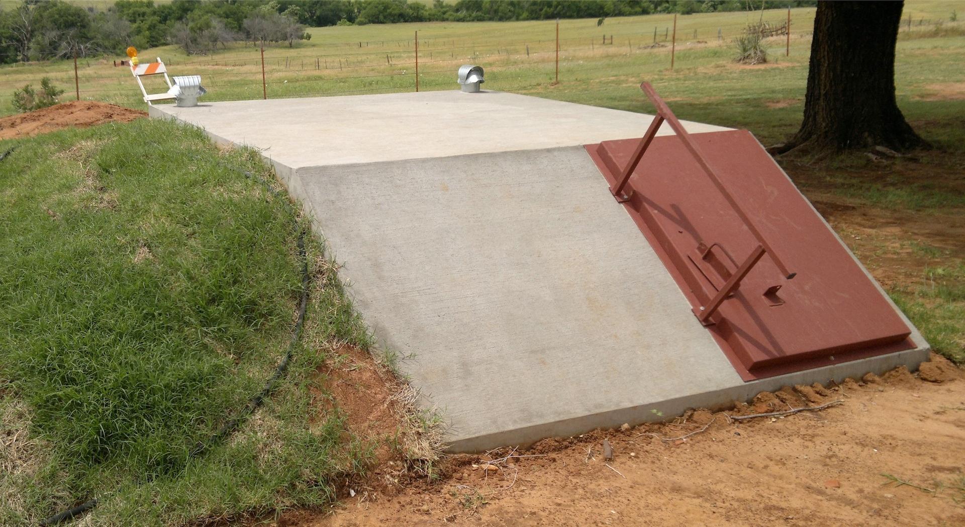 Sloped Front storm shelter shown with outside hand rail.