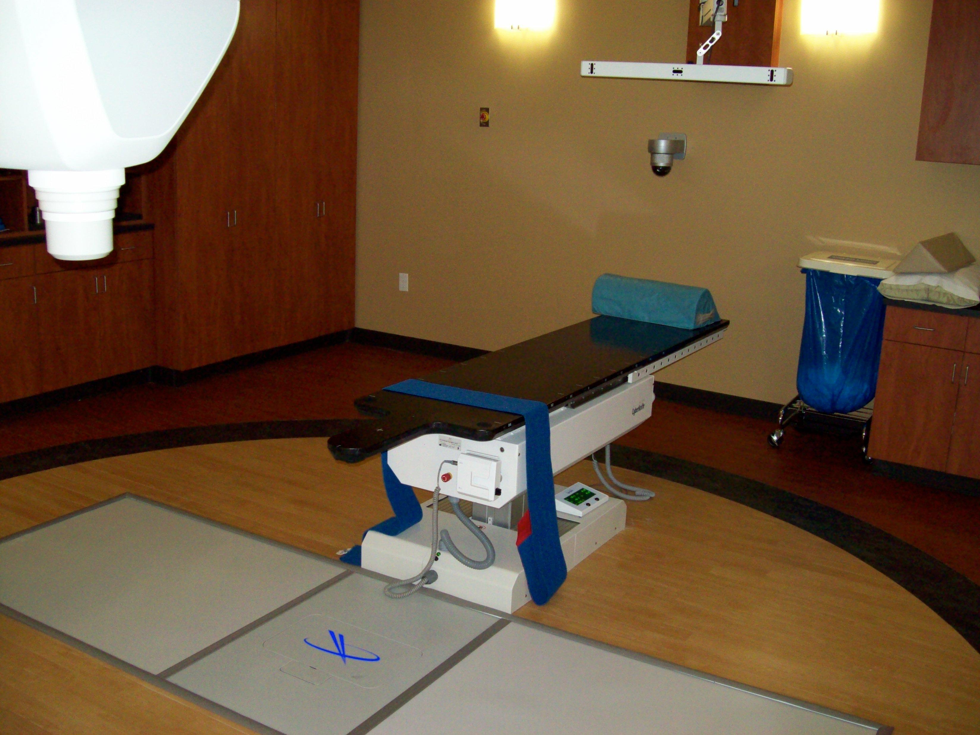 Patients lie on a treatment table while the CyberKnife's robotic arm moves around them firing targeted radiation beams from numerous angles.