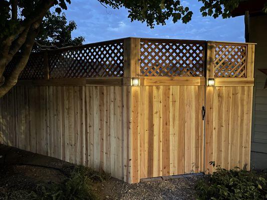 Custom cedar fence with redwood lattice cap and trim, steel posts and solar lighting.