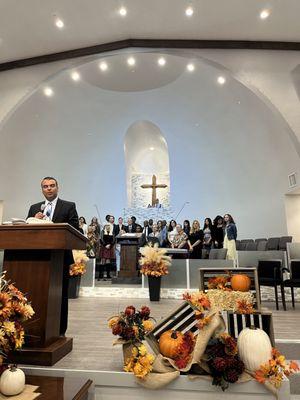 One of the pastors with the choir behind him.