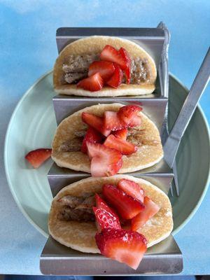 Three pancakes filled with sausage and strawberries - whip cream, optional.