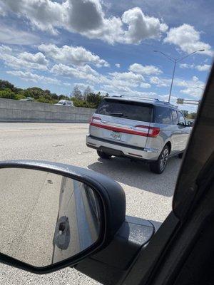 Driving very dangerously on I-95 with a Al packer dealer tag