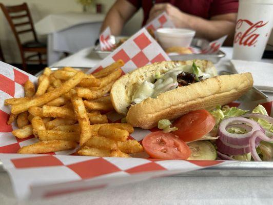 Ribeye po-boy with onions, bell peppers, and melted provolone cheese.