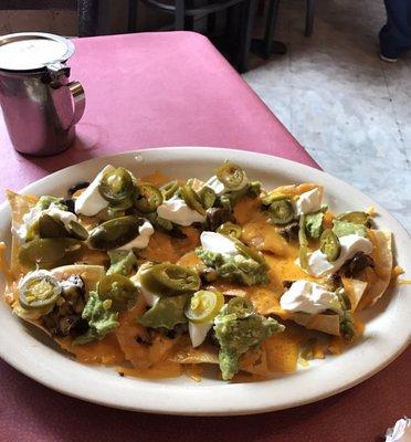 Beef fajita nachos. Salsa self-serving apparatus in background.