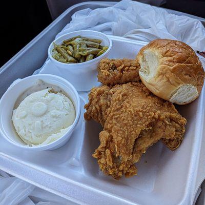 Chicken dinner with green beans, mashed potatoes, and roll.