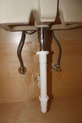 Plumbing work under the lavatory sink.