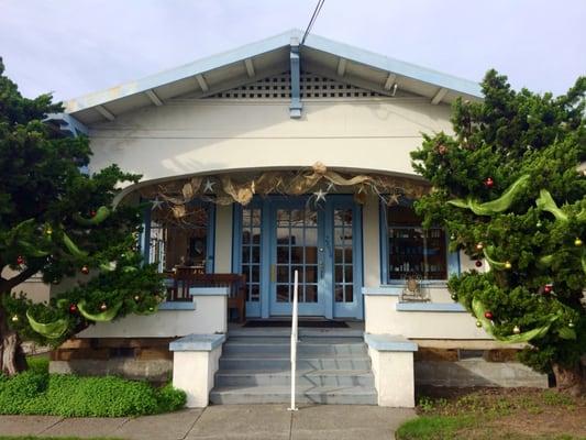 Look for the little white house with our namesake; two big juniper bushes on either side of the front steps!