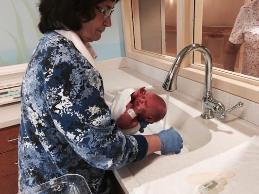 Nurse in the nursery washing my son for the first time