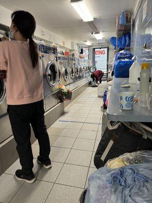 Grandma on the left, putting the laundry on the floor to washing. Disgusting!!