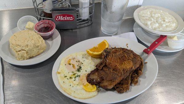 Fried Pork Chop & Eggs breakfast with grits and biscuit for the bread choice