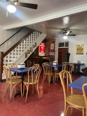 Indoor seating/tables. Antique ice cream machine and vintage milk bottles