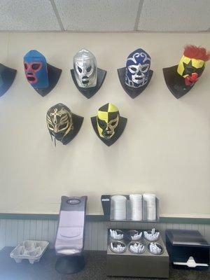 Wrestling masks looking out for the napkins and utensils.