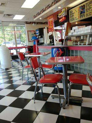 Indoor seating at tables or stools at window counter. Two Wire metal chairs and tables outside.