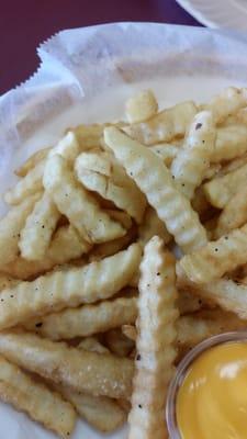 Apparently old grease, my fries are speckled with charred oil.