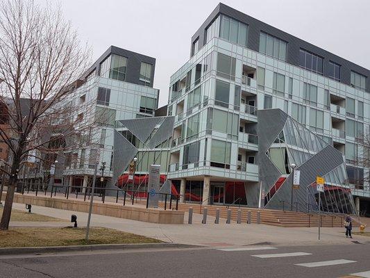 A modern contemporary building with lots of glass and lines with patterns.