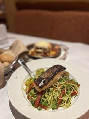 Salmon with pesto pasta, classic lasagna in the background