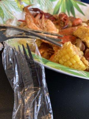 Bent metal fork and plastic silverware for crab...