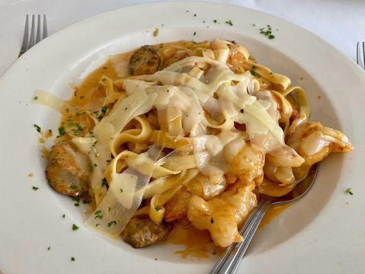 homemade fettuccine with chopped shrimp and sweet Italian sausage in a vodka pink sauce with shaved provolone