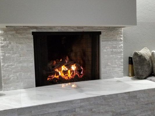 Family Room Fireplace with Stacked Quartz Uprights and a Beautiful Marble Seat.