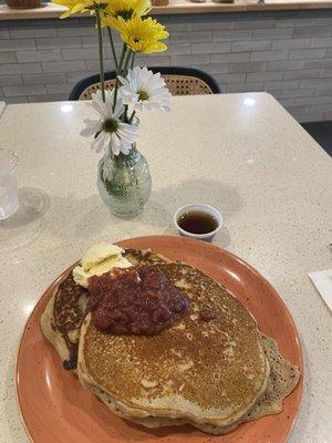 Buckwheat pancakes with maple syrup, fresh strawberry jam, and vanilla butter.