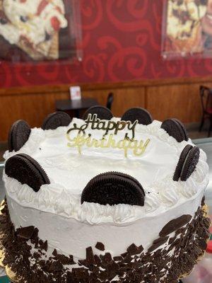 Cookies & Creamery ice cream cake with Happy Birthday cake topper.