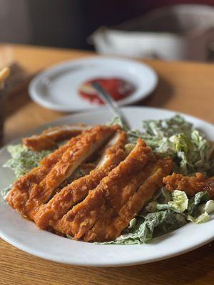 Caesar salad with buffalo chicken on top