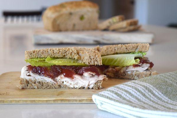 Hot Gobbler sandwich with roasted turkey, homemade cranberry sause, a garlic herb spread, lettuce, onion, and tomato. A seasonal special.