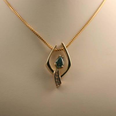 Blue Zircon and Diamond pendant in 14k yellow gold.