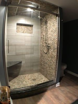 Five panel pocket door, semi custom Glass shower doors, bench seat and wall niche. Slate shower pan, ceiling and accent wall