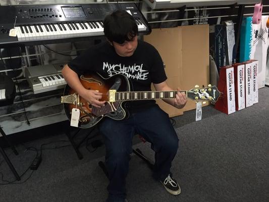 My son checking out a nice Ibanez artcore guitar.