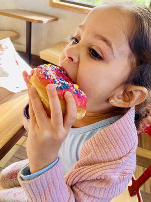 Customer enjoying strawberry iced donut with American flag sprinkles