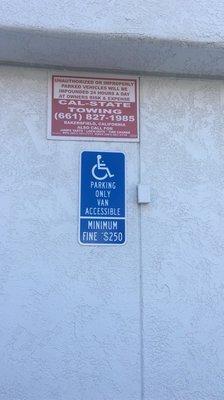 Tow warning sign on SIDE of the building and not next to the entrance like it's supposed to be