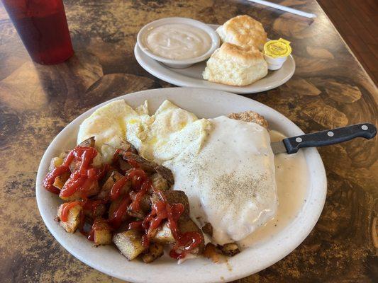 Chicken Fried Steak with creamy gravy, two eggs over easy, home fries, biscuits with a side of creamy gravy.