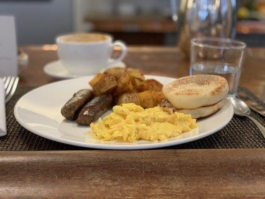 Classic Breakfast, scrambled eggs, pork sausage, potatoes, and an English muffin.