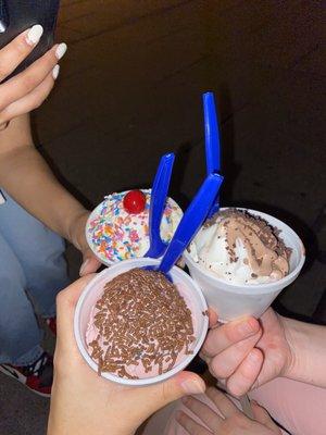 black raspberry with chocolate sprinkles, twist soft serve with cookie crunch, vanilla with rainbow sprinkles and a cherry