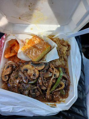 Hamburger steak on a bed of rice with smothered mushrooms glaze onions caramelize and green peppers cabbage sweet potatoes corn bread