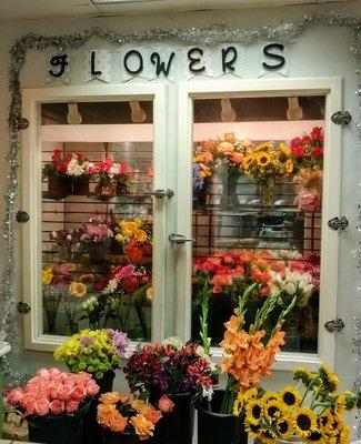 Our display cooler with fresh arrangements and loose cut stems.