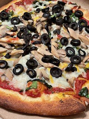 Vegan pizza with olives, mushrooms and spinach