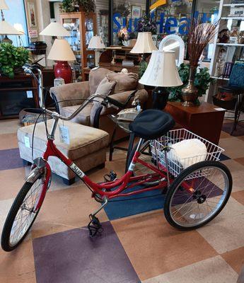 A neat tricycle with basket, located in the furniture section, is in great condition.