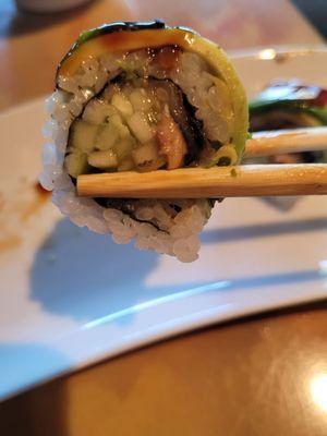 Tiny piece of eel in cucumber slices and undercooked rice