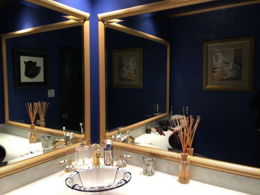 Double vanity mirrors made to brighten a dark interior bathroom.