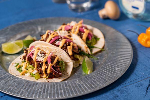 Braised shortrib tacos with grilled flour tortillas, sriracha Mayo, pickled habanero onions, guacamole and cilantro.