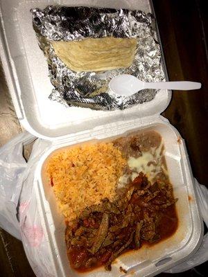 Bistec Ranchero y Arroz con frijoles w/ Corn tortillas  Strips of steak cooked in a spicy tomato and chili sauce.