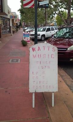 front of store faded and dreary. no one wants to go in. faded posters. owner hides during Tue sidewalk sale