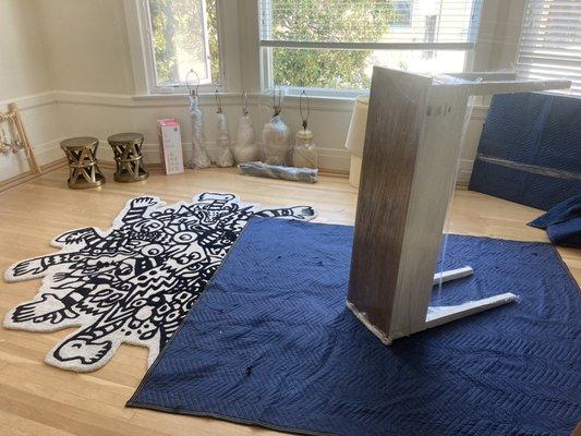 Covering each piece of furniture with plastic wrap, moving blanket and plastic wrap to ensure everything is protected