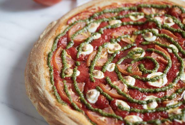 Margherita Pizza - Tomatoes, Fresh Mozzarella, Original Pizza Sauce topped with a swirl of Basil Pesto.