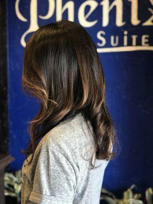 Soft natural highlights. Balayage caramel tones on natural dark hair.